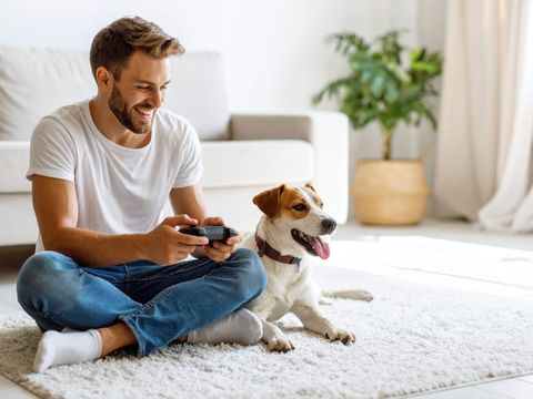 Man relaxing at home with his dog on a freshly cleaned carpet